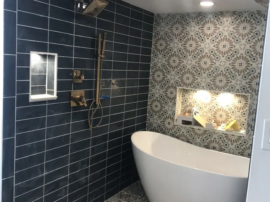 Finished bathroom with navy tile shower and freestanding tub