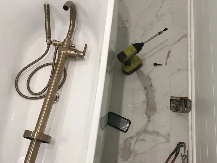 Freestanding tub with a brass floor-mount tub filler
